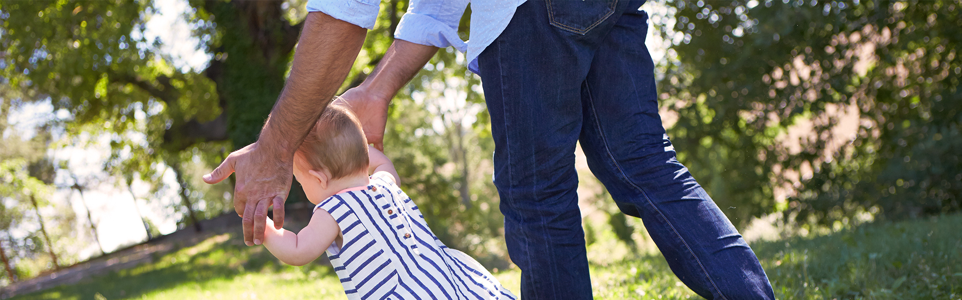 Father helping baby to walk